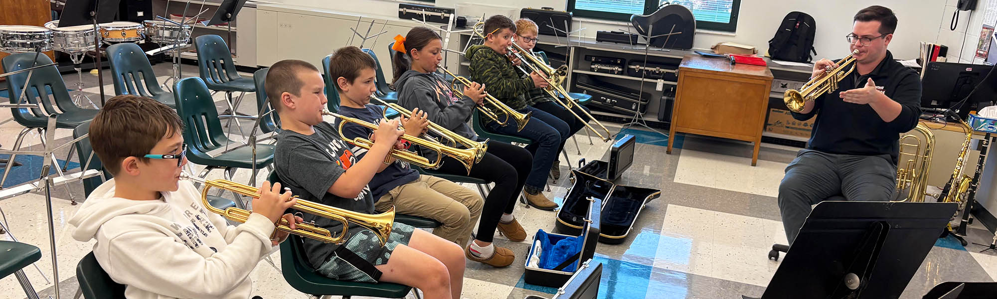 Music students practicing horned instruments with their teacher