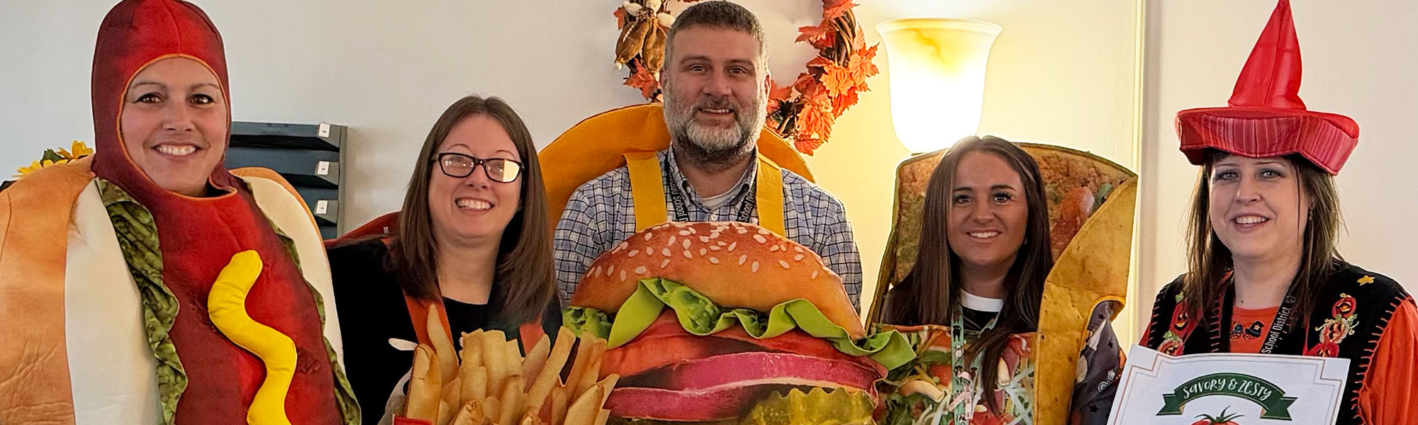 Five happy staff member dressed in costume for Halloween