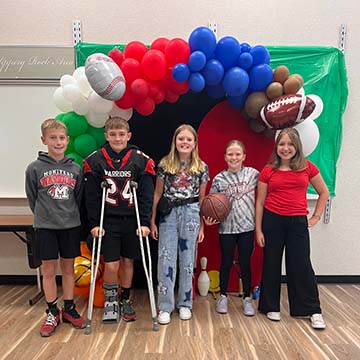 Students in front of a balloon arch