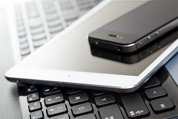 A phone and tablet on a keyboard