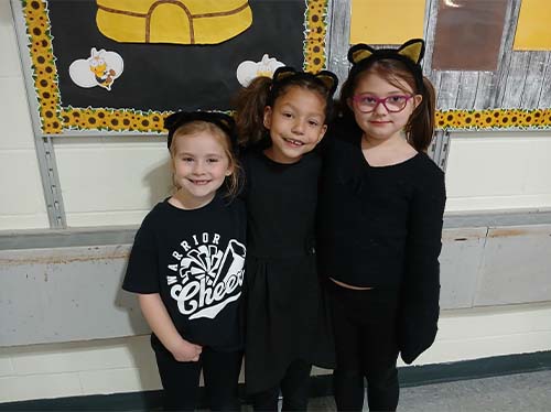 three students dressed as cats