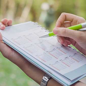 Parent updating personal calendar with a pen