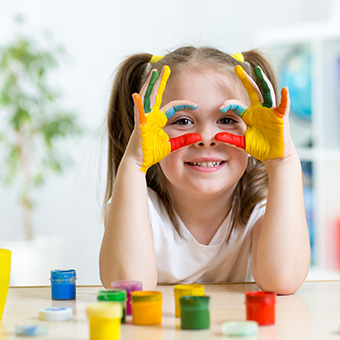 Female elementary student with painted hands