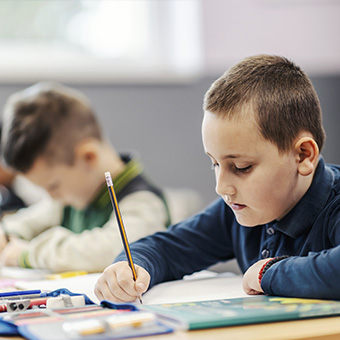 Student writing at his desk