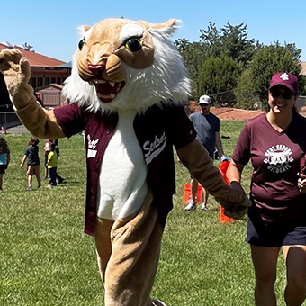 School mascot with a teacher outside