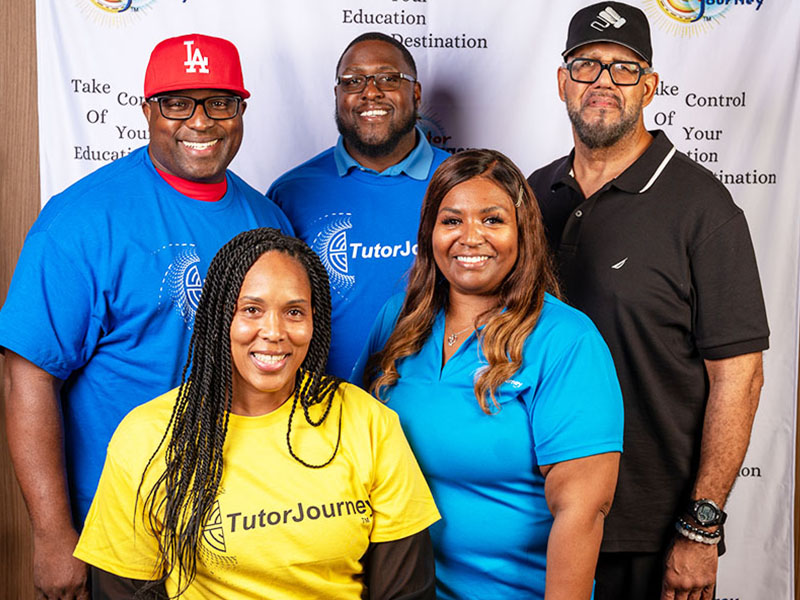 Five happy staff members posing for a picture