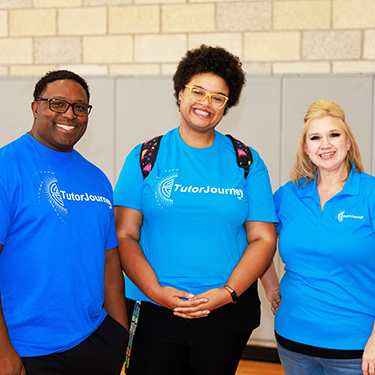 Three happy staff members in blue shirts