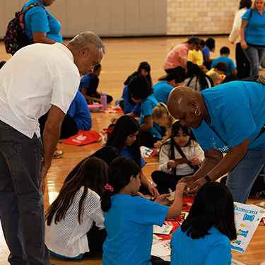Two teachers helping a group of students with a project at Phoenix Raceways
