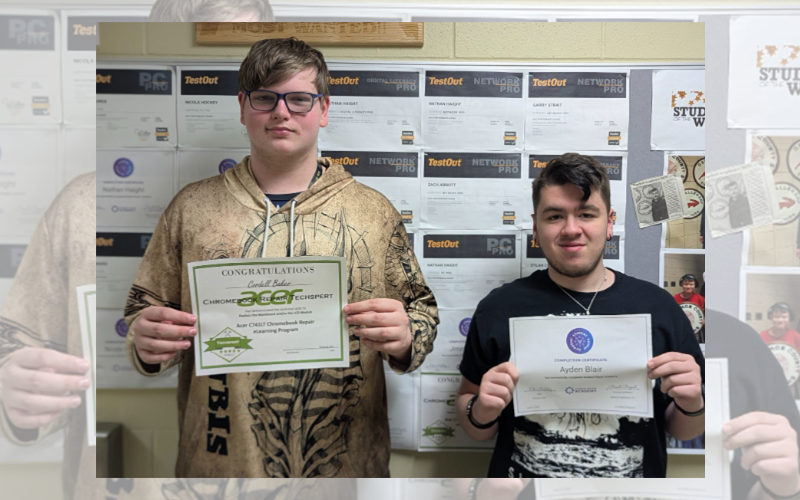 two students holding certificates of completion