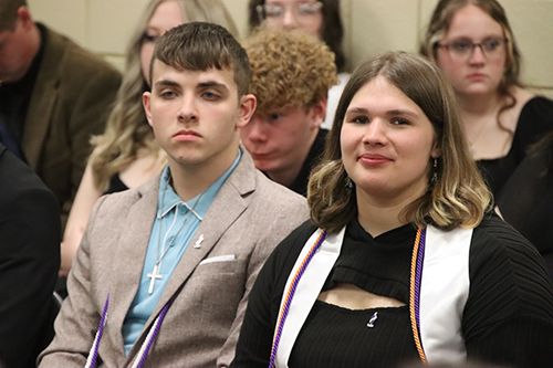 Two students sitting during the ceremony