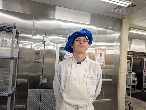 Happy culinary student wearing a blue cap