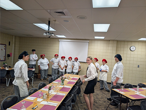 Culinary students preparing the dining room for guests