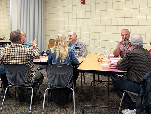 Group of dinner guests engaged in a conversation at a table
