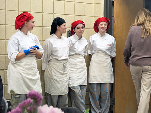 Four culinary students standing in the dining room
