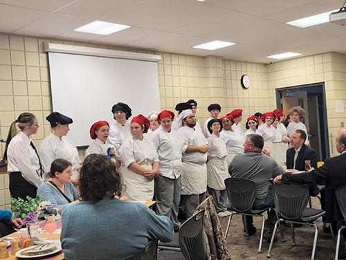 Group of culinary students in front of dinner guests