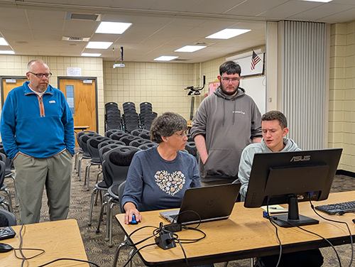 Network students providing a free computer clinic to local residents in the computer lab