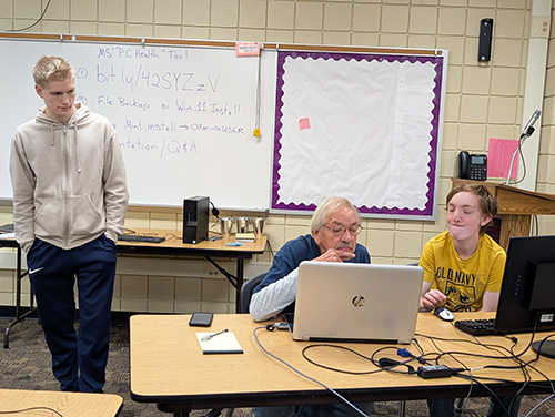 Network students providing a free computer clinic to local residents