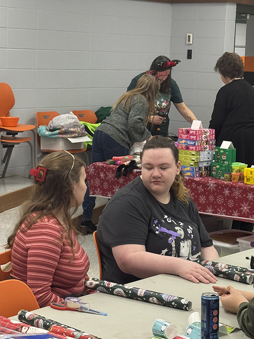 Students helping at a wrapping gift table