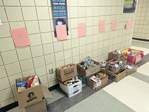 Donated food items filled in boxes in school hallway