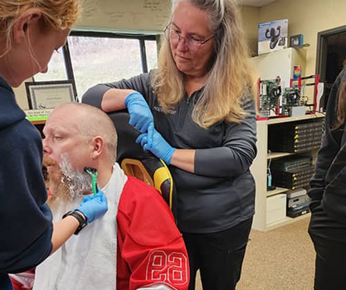 Student practicing her shaving skills on a very brave teacher, Mr. Bryant