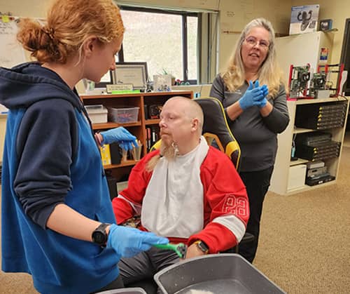 Teacher watching as health student shaves a very brave teacher