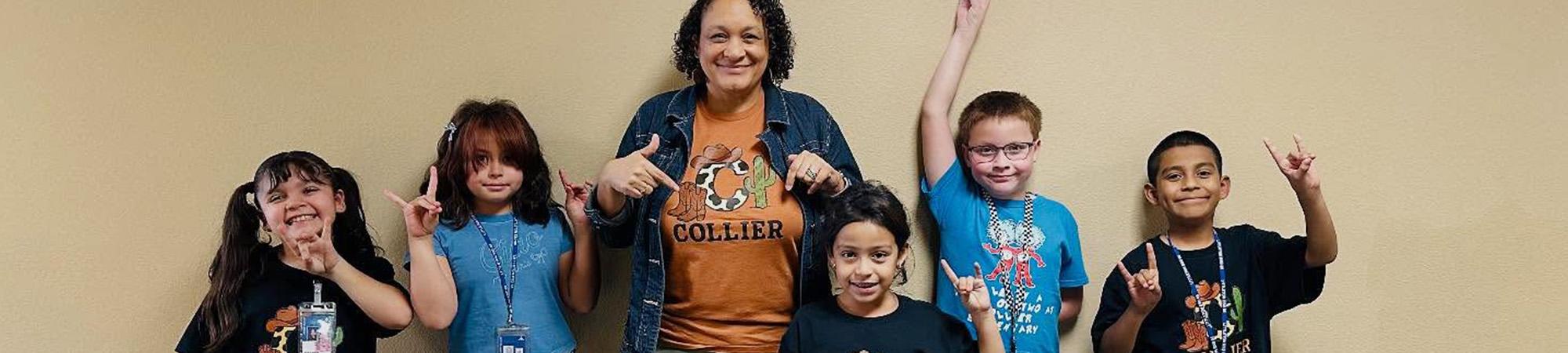 Group of happy students with teacher wearing Collier spirit t-shirts