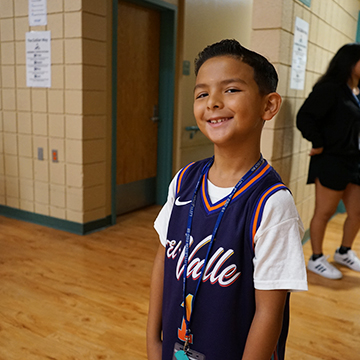 Happy male student smiling for the camera in the school hallway