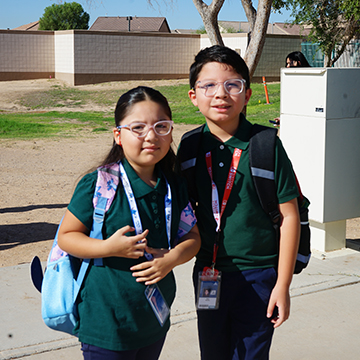 Two happy students outside on the school campus