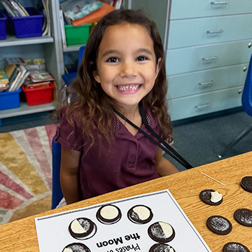 Happy elementary student sitting at her desk
