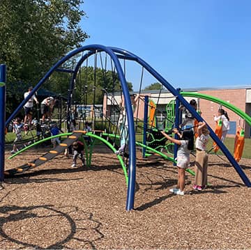 Adult helping a student get on the school bus