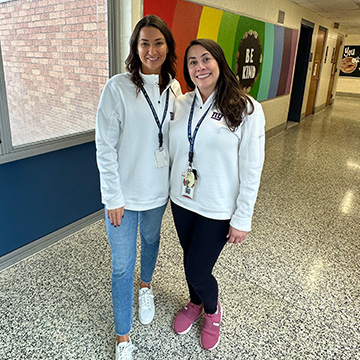Mrs. Suzanne Lang and Ms. Dara Weiss smiling in the school hallway