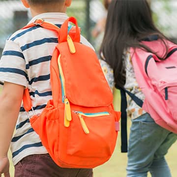 Two students walking with their backpacks