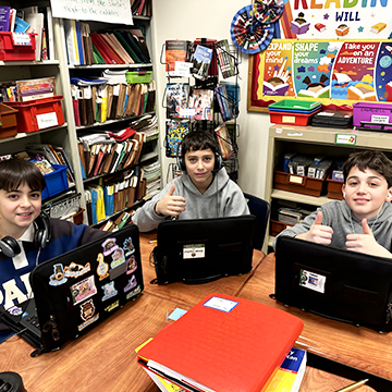 Three happy boys with laptop computers