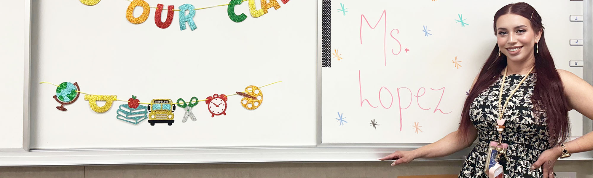 Ms. Lopez in front of her welcome board