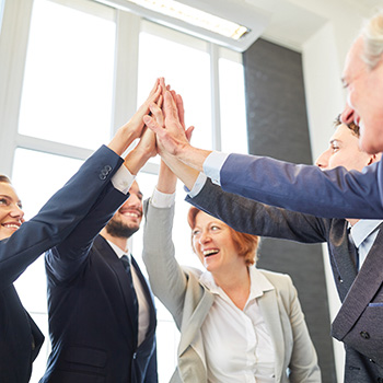 Men and women doing a high five in the center of a circle