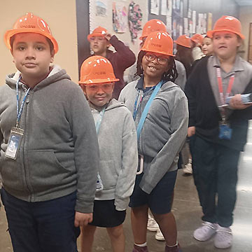 Students in the hallway wearing hardhats