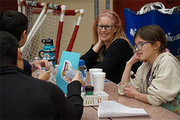 Students and teachers having a discussion while sitting at the cafeteria