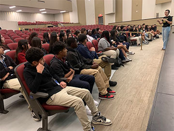 Students in the auditorium listening to a speaker