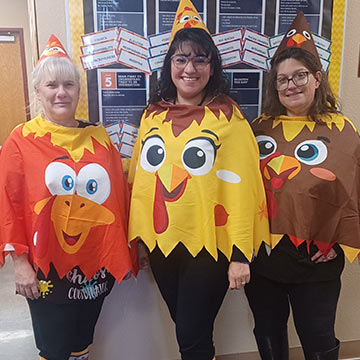 Three teachers in chicken shirt costumes