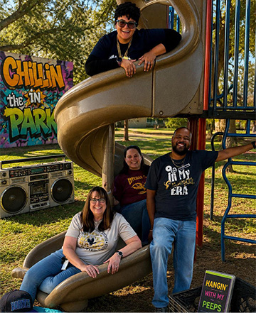 Staff members posing on a slide in the park