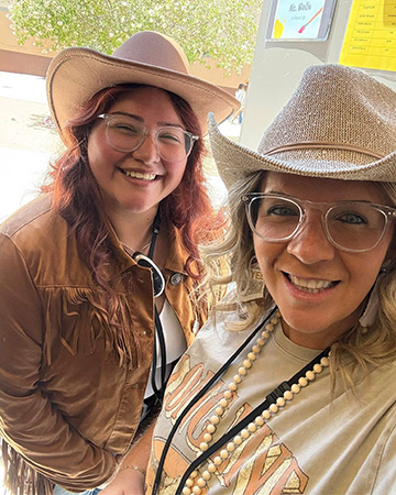Two adults wearing cowgirl hats