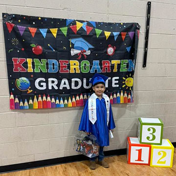 Kindergarten student in graduation cap and gown