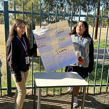 sidebar_FAQ_110518 Two girls holding up a poster outside