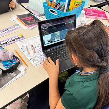 Girl sitting at her desk using a laptop