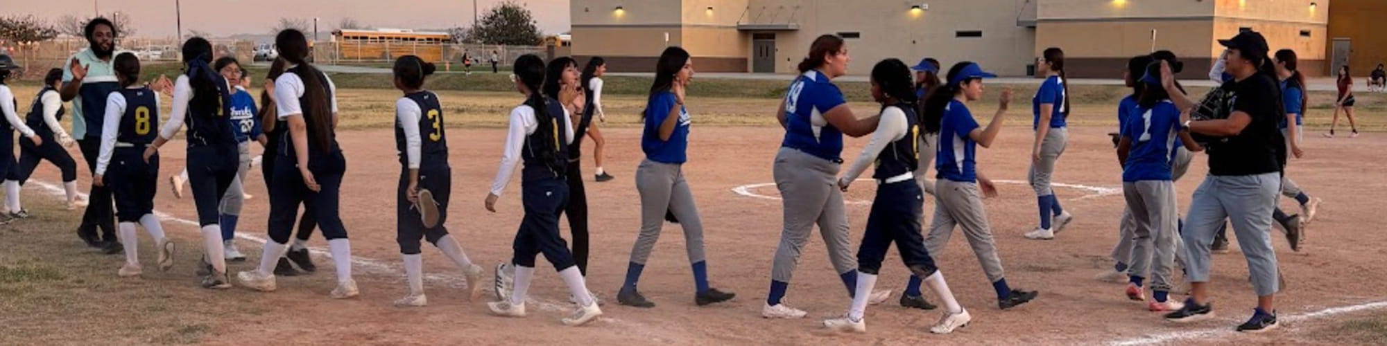 Two Littleton girls softball teams giving high fives