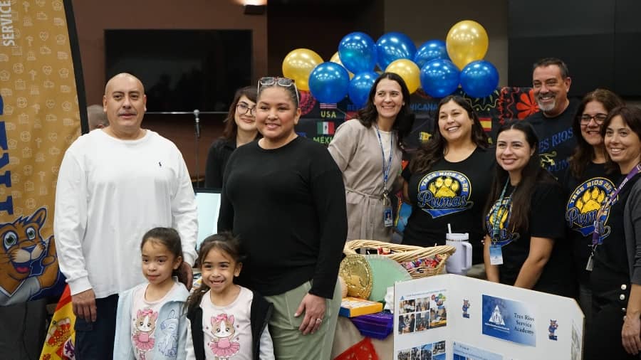 group of parents, teachers, and students posing at school choice night