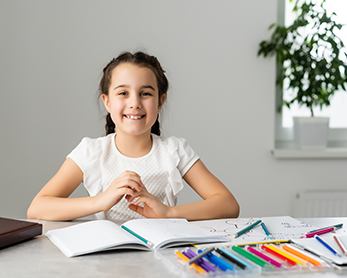 Proud girl smiling from her desk