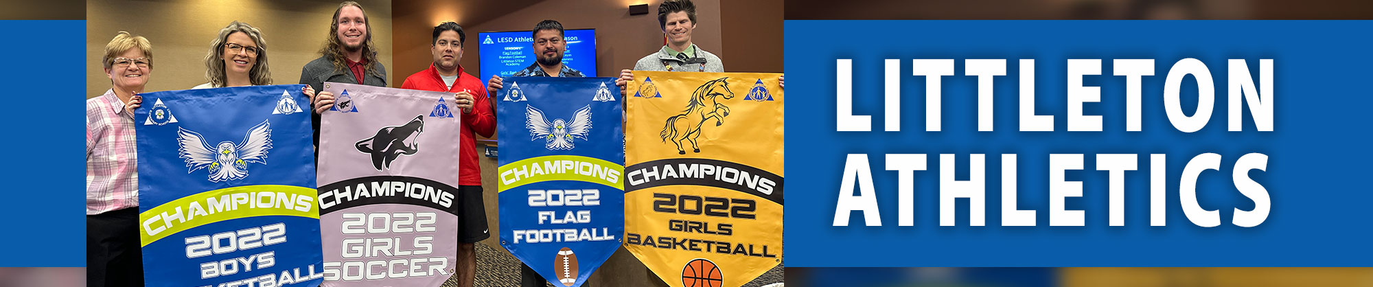 Littleton Athletics - Teachers holding championship banners for different sports