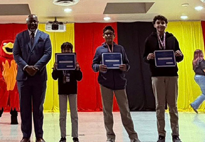 Three students with their AASA State Assessment certificates and the superintendent