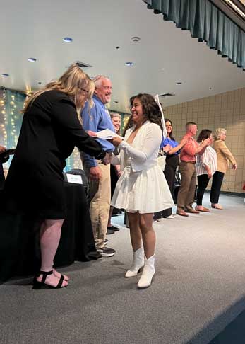 student going through line of adults to receive a certificate